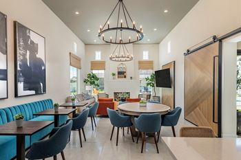 a dining room with tables and chairs and a living room with a fireplace